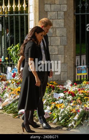 Windsor, Regno Unito. 10th Settembre 2022. Il Principe Harry e Meghan, il Duca e la Duchessa di Sussex, considerano i tributi floreali che si trovano fuori dalla porta di Cambridge al Castello di Windsor dopo la morte della Regina Elisabetta II La regina Elisabetta II, il monarca più longevo del Regno Unito, morì a Balmoral all'età di 96 anni il 8th settembre 2022 dopo un regno della durata di 70 anni. Credit: Notizie dal vivo di Mark Kerrison/Alamy Foto Stock