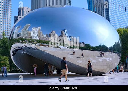 Chicago, USA - Agosto 2022: Visitatori del Millennium Park godendo le riflessioni nel Bean. Foto Stock