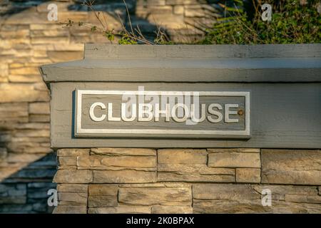 La Jolla, California - etichetta Clubhouse su una parete esterna con pietre. Scritta bianca dipinta sullo sfondo grigio in legno sulla parte superiore della pietra wa Foto Stock