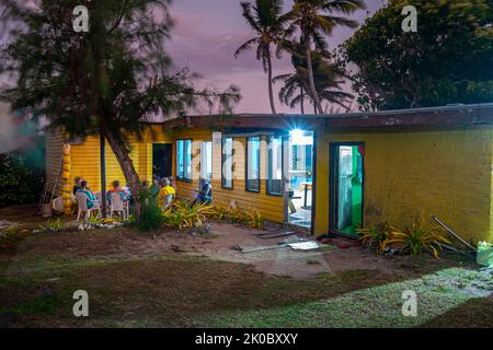 Gli ospiti che socializzano all'aperto in serata presso la famiglia sull'Isola di Nanuya Lailai, sulle Isole Yasawa e sulle Fiji Foto Stock