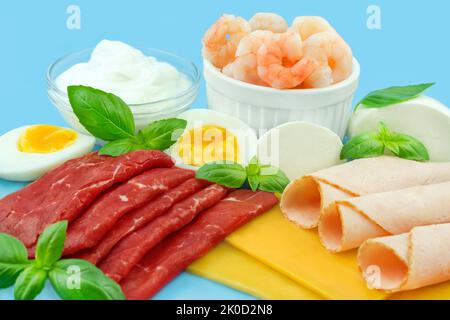 Vari alimenti con proteine su sfondo blu Foto Stock