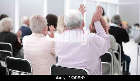 Vista posteriore di un anziano che ascolta una lezione Foto Stock