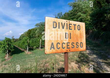 Un cartello bianco arrugginito senza trasgressione in un vigneto nel villaggio di Affi in Italia. Foto Stock