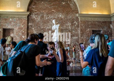 Gente che si aggira intorno a Venere di Milo; 130–100 a.C.; marmo; altezza: 203 cm, Museo del Louvre, il museo più visitato del mondo e un punto di riferimento storico Foto Stock