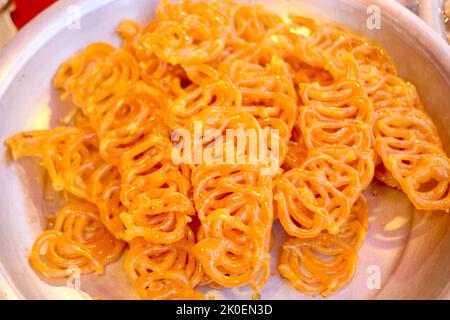 Croccante dolce Jalebi, Jilapi, zulbia, mushabak o zalabia in piatto ovale bianco. Fuoco selettivo. Foto Stock