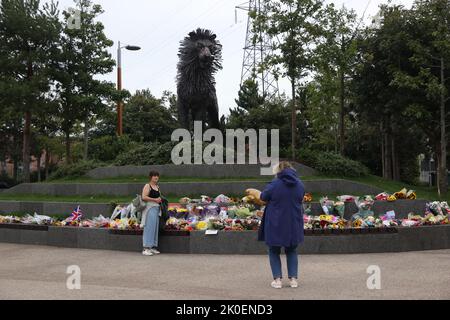 Tributi floreali alla statua di Aslan in CS Lewis Square nella parte orientale di Belfast, dopo la morte della regina Elisabetta II Data immagine: Domenica 11 settembre 2022. Foto Stock