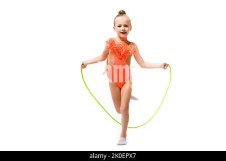 Ragazza sportiva bambino ginnastica in salto leotard con corda, professionista piccolo acrobata, stile di vita sano e passione per il bambino Foto Stock