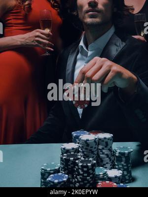 L uomo alla roulette tavolo circondato da belle donne Foto Stock