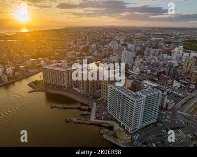 Il sole si estende sulla distesa città costiera Foto Stock