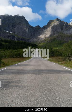 Strada vuota che conduce alle montagne a Lofoten, Norvegia Foto Stock