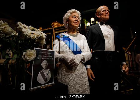 Kuala Lumpur, Malesia. 11th Set, 2022. Fiori e un tributo sono allestiti accanto a statue di cera che raffigurano la defunsa Regina Elisabetta II (L) e suo marito, il defunto Principe Filippo, Duca di Edimburgo, al Museo delle cere dei tappeti rossi, i-City a Shah Alam, alla periferia di Kuala Lumpur. Il più lungo monarca regnante della Gran Bretagna, la regina Elisabetta II, morì il 8 settembre all'età di 96 anni nella sua tenuta scozzese, Balmoral Castle. (Foto di © Wong Fok Loy/SOPA Images/Sipa USA) Credit: Sipa USA/Alamy Live News Foto Stock