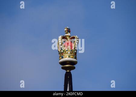 Una decorazione a corona è vista sulla cima di un flagpole come Union Jacks sono installati lungo il Mall che conduce a Buckingham Palace dopo la morte della Regina Elisabetta II La Regina morì il 8th settembre, all'età di 96 anni. Foto Stock