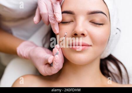 Face Lifting PDO suture Operation. Tecnica innovativa di New thread lift, cosmetologist preparandosi a fare la procedura per il cliente femminile, selezionare il Foto Stock