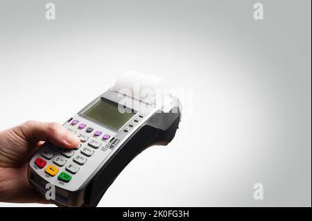 Cash terminal in mano di un uomo su sfondo bianco. Acquisti all'ingrosso e al dettaglio, vendite, carte bancarie e di credito, servizi. Minimalismo. C'è f Foto Stock