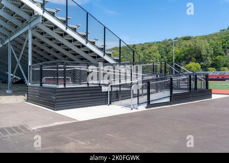 Rampa accessibile con sedia a rotelle con ringhiere e superficie antiscivolo presso lo stadio vuoto in metallo. Posizione non descrittiva senza persone. Foto Stock