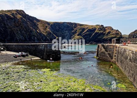 Kayak nel porto storico di Mullion Cove a Mounts Bay Cornwall Inghilterra Regno Unito. 13th agosto 2022. Mullion Cove o Porth Mellin - porto a ovest c Foto Stock