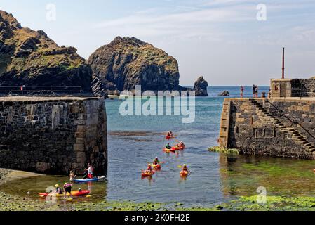 Kayak nel porto storico di Mullion Cove a Mounts Bay Cornwall Inghilterra Regno Unito. 13th agosto 2022. Mullion Cove o Porth Mellin - porto a ovest c Foto Stock