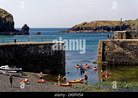 Kayak nel porto storico di Mullion Cove a Mounts Bay Cornwall Inghilterra Regno Unito. 13th agosto 2022. Mullion Cove o Porth Mellin - porto a ovest c Foto Stock