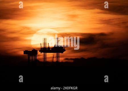 Tramonto sul giacimenti petroliferi, tramonto sulla piattaforma satellitare Lennox nel Mare d'Irlanda, parte dei complessi di impianti petroliferi e di gas Douglas a Liverpool Bay, Inghilterra, Regno Unito Foto Stock