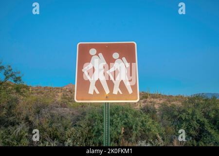 Cartello per sentieri escursionistici contro la pendenza e il cielo blu al Sabino Canyon state Park - Tucson, Arizona. Simbolo del cartello con l'illustrazione di due escursionisti. Foto Stock