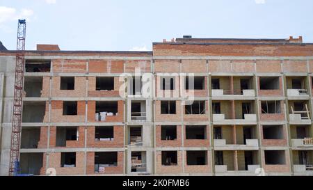 Costruzione di una casa in mattoni a più piani. Fase di costruzione di un edificio a più piani. Edificio a più piani incompiuto. Mattone edificio sotto c Foto Stock