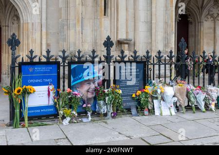 Winchester, Hampshire, Regno Unito. 11th settembre 2022. Dopo la morte della Regina Elisabetta II, avvenuta il 8th settembre 2022, la gente ha messo fiori e tributi in onore della Regina Elisabetta II fuori dall'ingresso della Cattedrale di Winchester. Il paese è in un periodo di lutto nazionale fino al suo funerale. Foto Stock