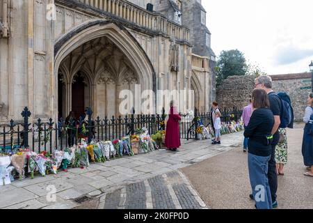 Winchester, Hampshire, Regno Unito. 11th settembre 2022. Dopo la morte della Regina Elisabetta II, avvenuta il 8th settembre 2022, la gente ha messo fiori e tributi in onore della Regina Elisabetta II fuori dall'ingresso della Cattedrale di Winchester. Il paese è in un periodo di lutto nazionale fino al suo funerale. Foto Stock