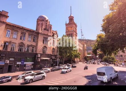 Tbilisi, Georgia - 07 23 2022: Calda vista di un giorno estivo lungo Brothers Kakabadzeebi Street con la torre della Georgian National Academy of Sciences Building e. Foto Stock