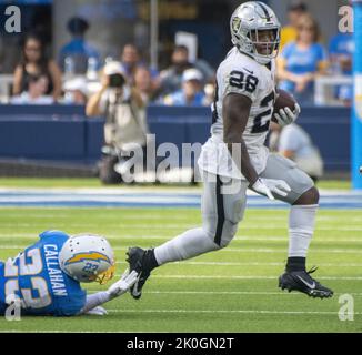 Inglewood, Stati Uniti. 11th Set, 2022. Il ritorno dei Raiders Josh Jacobs (28) rompe l'acclamamento del ritorno dei Chargers Bryce Callahan (23) durante la seconda metà di una partita tra i Los Angeles Chargers e gli Oakland Raiders al SoFi Stadium di Inglewood CA, domenica 11 settembre 2022. Foto di Mike Goulding/UPI Credit: UPI/Alamy Live News Foto Stock