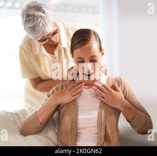 Tutte le donne della nostra famiglia hanno portato questo. Una donna anziana che dà a sua figlia una collana di perle. Foto Stock