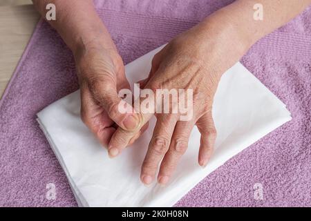 Primo piano, le mani di una donna anziana con rughe. Auto massaggio, assistenza sanitaria Foto Stock