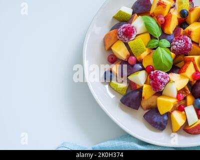 Macedonia di frutta con susina fresca, pesca, nettarine, pera e lamponi congelati Foto Stock