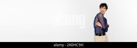 giovane modello non binario in camicia manica lunga guardando lontano isolato su grigio, banner, immagine stock Foto Stock