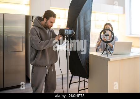 Cameraman e un vlogger preparano per filmare un vlog Foto Stock