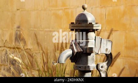 Un primo piano di una testa di una pompa dell'acqua manuale all'aperto Foto Stock