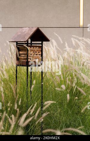 Un'immagine verticale di un hotel in legno e metallo nel giardino Foto Stock