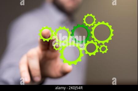 Un uomo che si raggiunge per gli ingranaggi verdi illustrati Foto Stock