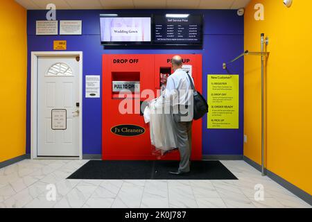 Una persona che utilizza un chiosco di lavaggio a secco automatico 24hr presso un J's Cleaners a New York, New York. Foto Stock