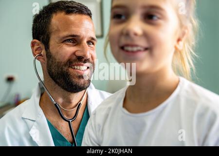 Il medico esamina un bambino con stetoscopio nella sala esame. Concetto di assistenza sanitaria ai bambini Foto Stock