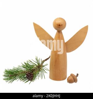Figura di angelo di legno girata decorata con coni di pino e aghi di pino isolati su bianco Foto Stock