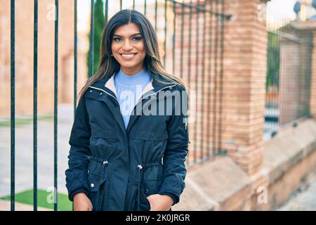 Bella donna ispanica sorridente confidente in città Foto Stock