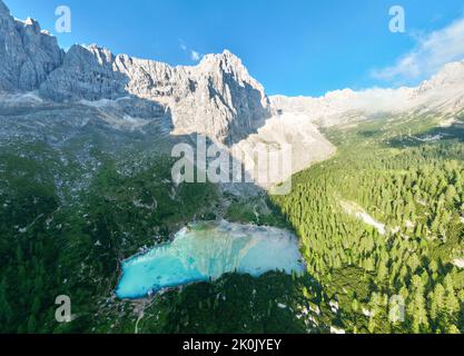 Vista dall'alto, splendida vista panoramica sul Lago Sorapis con le sue acque turchesi circondate da una foresta e montagne. Foto Stock