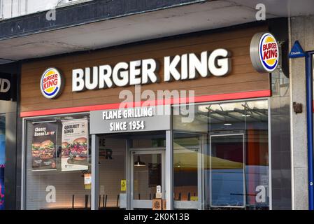 All'esterno di un negozio Burger King in Inghilterra che mostra le indicazioni per le offerte speciali sulla finestra anteriore. Foto Stock