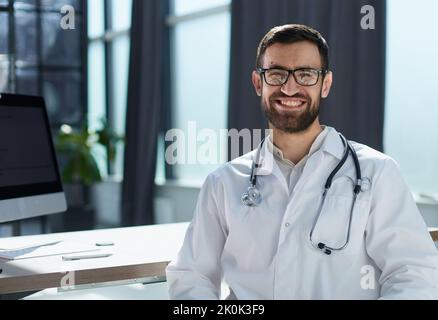 Felice giovane uomo medico sorridere bello Foto Stock