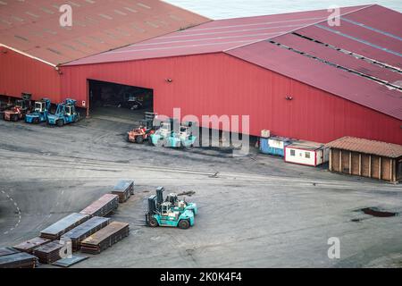 Vista aerea dei magazzini metallici con carrelli elevatori e file di carico parcheggiati a terra Foto Stock