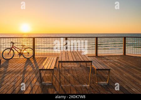 Tavolo da picnic sulla spiaggia al tramonto, Somerton Park, South Australia Foto Stock