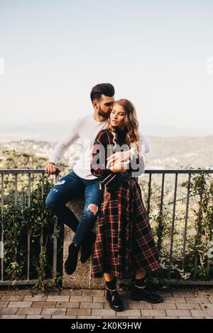 Giovane uomo attraente bacia la sua ragazza in guancia nelle strade di Barcellona, Spagna Foto Stock