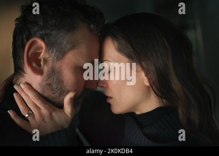 Primo piano di una donna che piange quando abbraccia il marito. Foto Stock