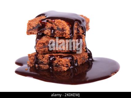 Pezzi di torta di brownie isolato su sfondo bianco. Torta con sciroppo al cioccolato fondente Foto Stock
