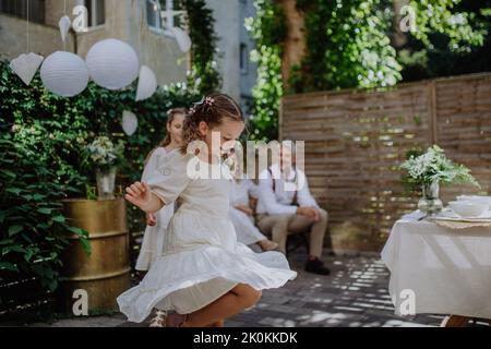 Piccolo bambino ballare e godersi la festa di nozze all'aperto dei suoi genitori. Foto Stock